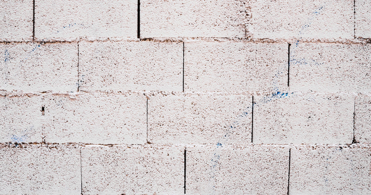 Mur en parpaings peint à la peinture blanche.