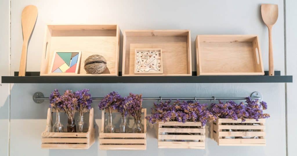 Plateaux et casier en bois placés sur une étagère de cuisine.