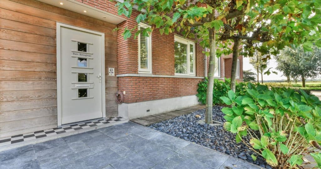 Entrée de maison de ville, avec un pavage en dalles et de la végétation.